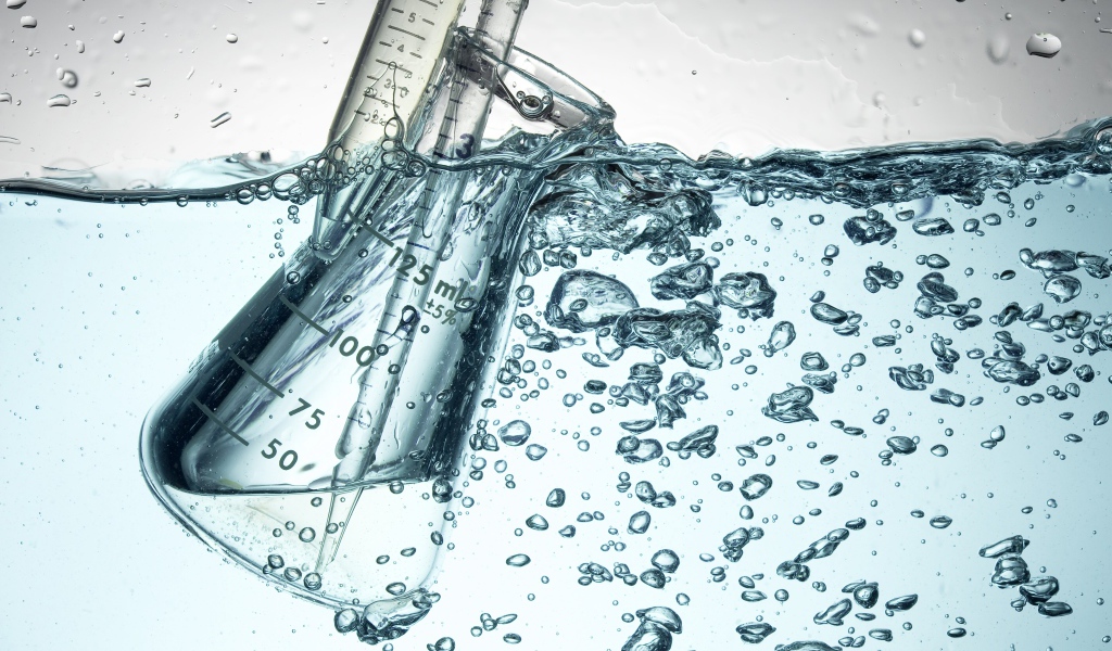 Измерительная чашка в воде с пузырями 