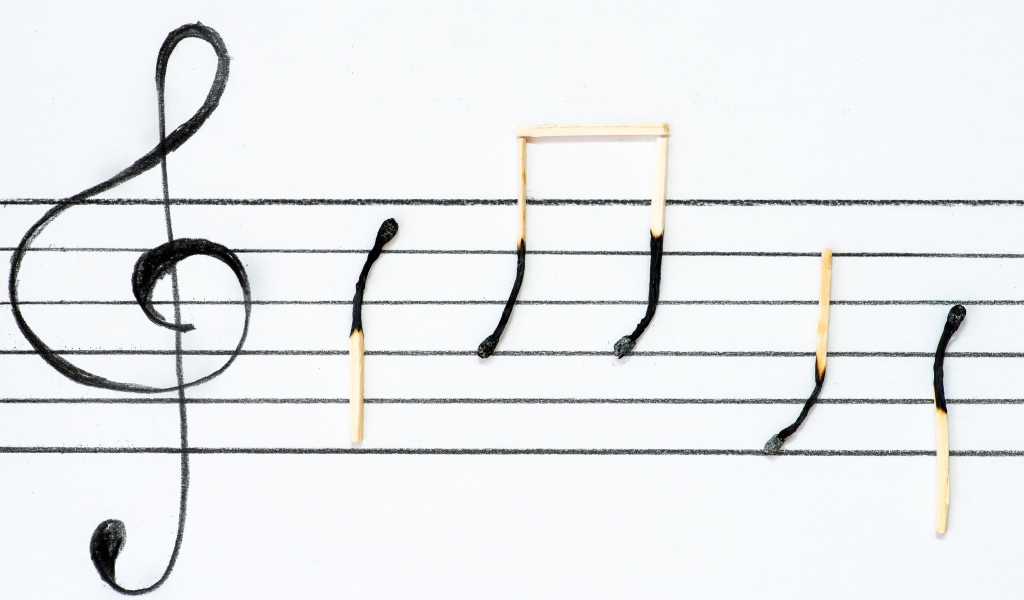 Ноты из сгоревших спичек на белом фоне