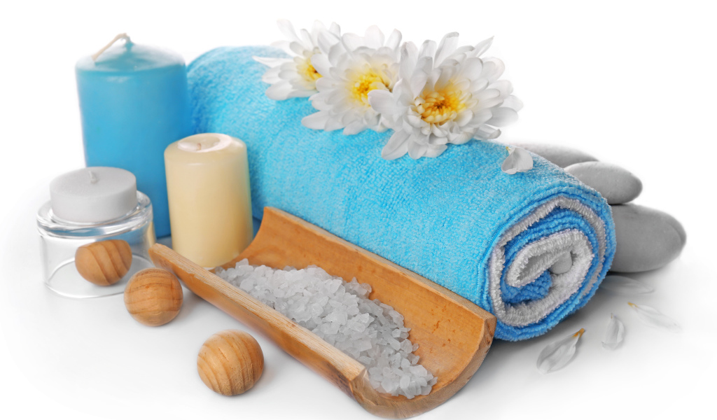 Полотенце, свечи, соль и цветы хризантемы на белом фоне