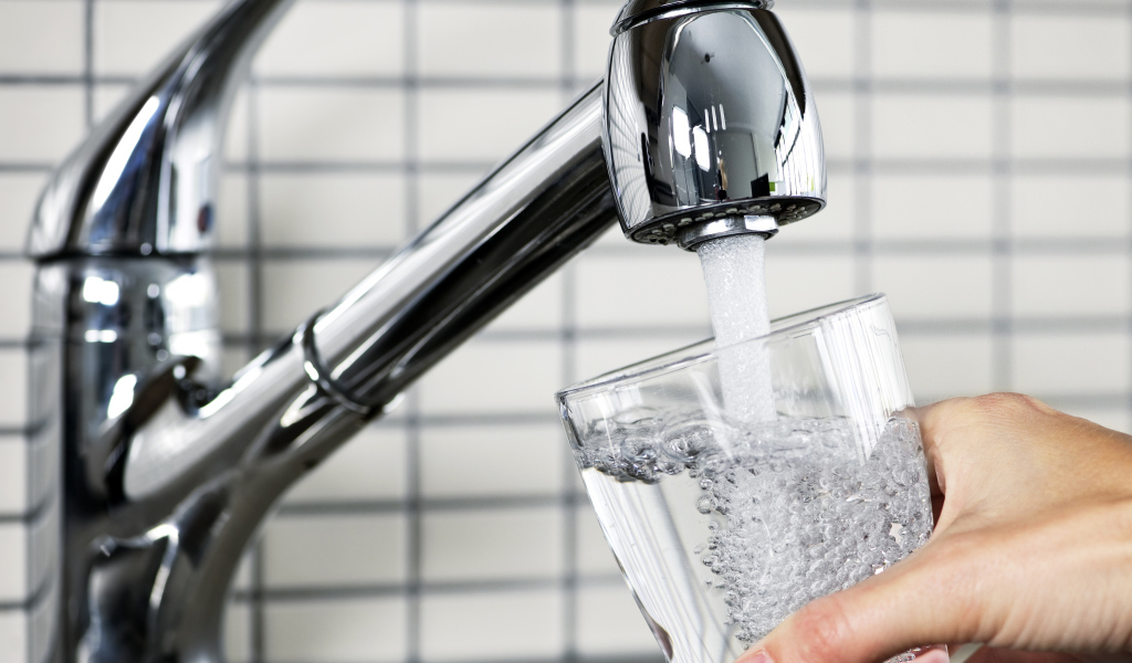 Водопроводный кран со стаканом воды