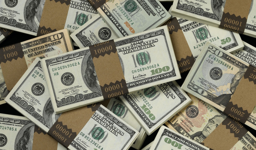 Много пачек купюр по сто долларов