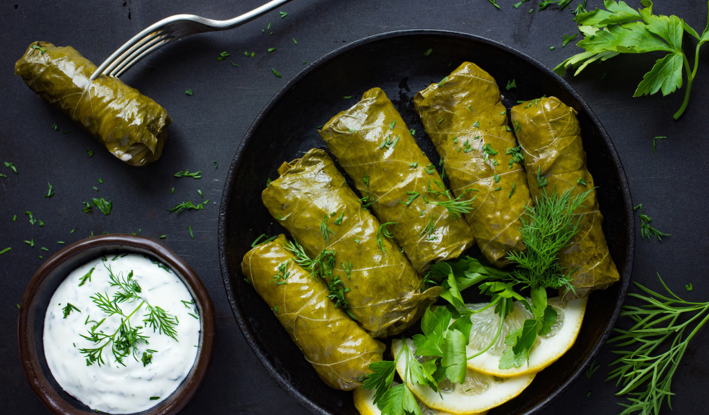 Аппетитная долма с кусочками лимона на столе 