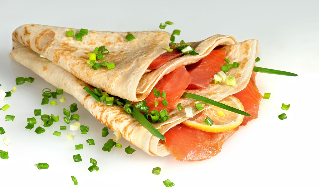 Аппетитный блин с красной рыбой и зеленым луком