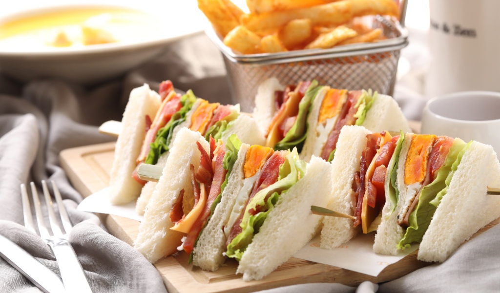 Аппетитные сэндвичи к завтраку на столе 