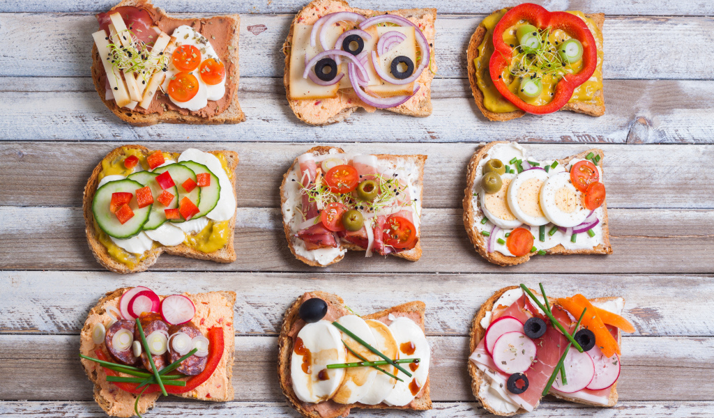 Аппетитные бутерброды на деревянном столе вид сверху