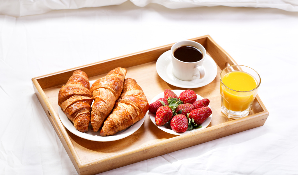 Круассаны, клубника, апельсиновый сок и кофе на завтрак