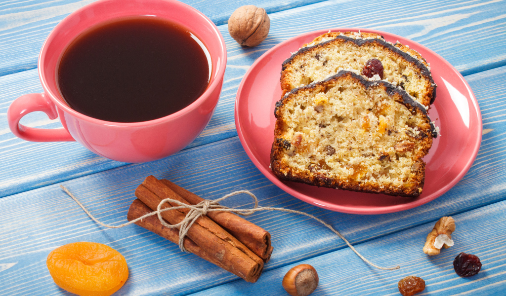 Кекс с корицей, орехами и курагой на столе с чашкой чая