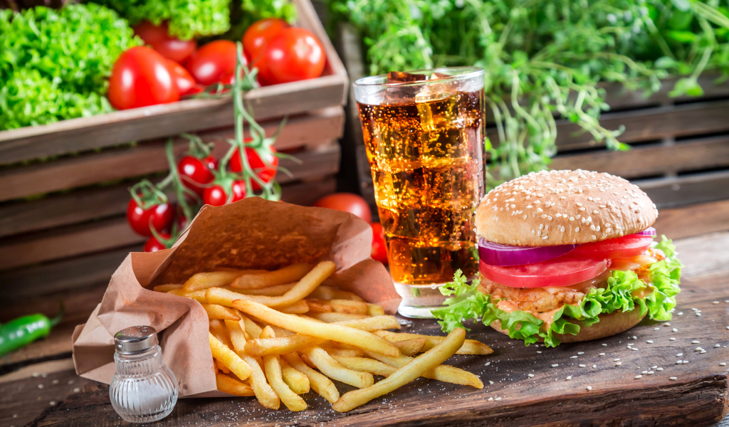 Картофель фри, пиво и сэндвич на столе 