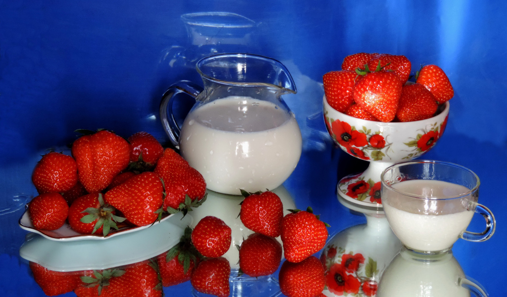 Свежие аппетитные ягоды клубники на столе с молоком