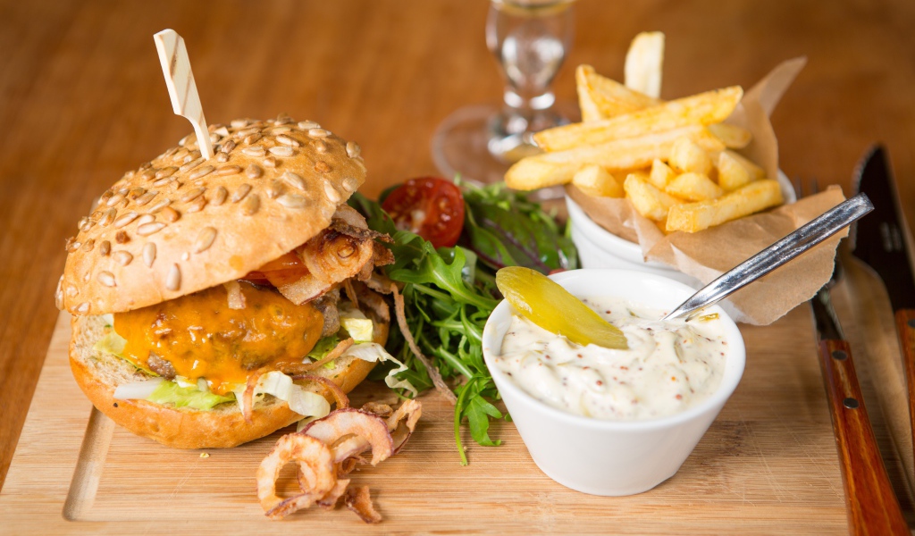 Гамбургер и картошка фри на столе с соусом