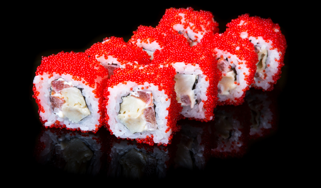 Японские роллы с красной икрой на черном фоне 