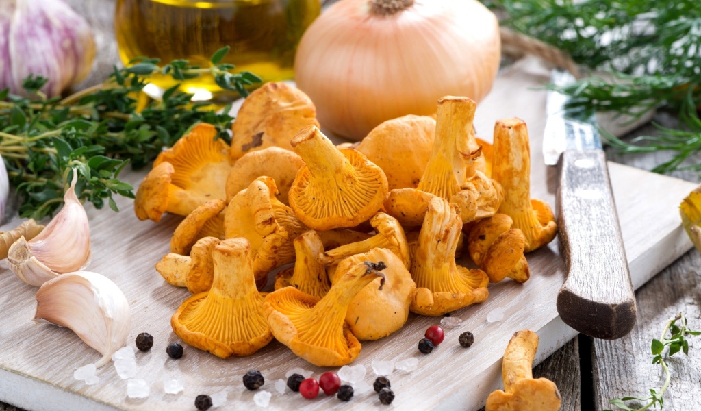 Грибы лисички и овощи на деревянной доске 