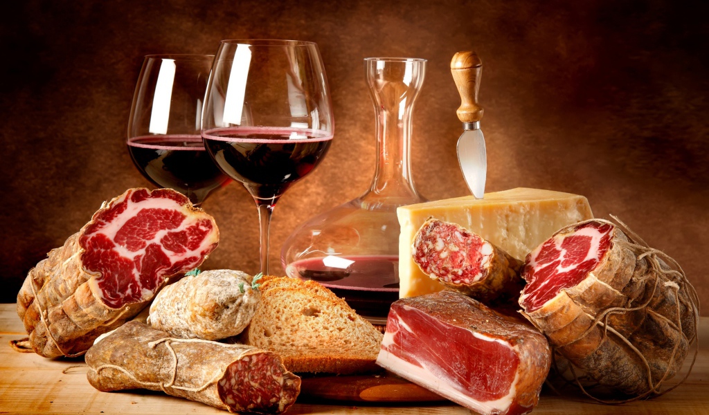 Красное вино и мясные продукты на столе  