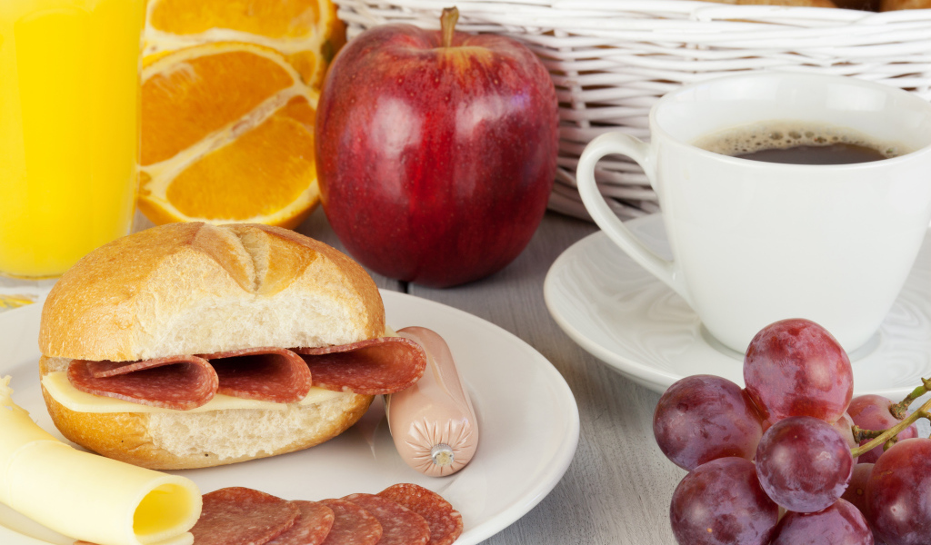 Бутерброд с сыром и колбасой и сок с яблоком и виноградом на завтрак