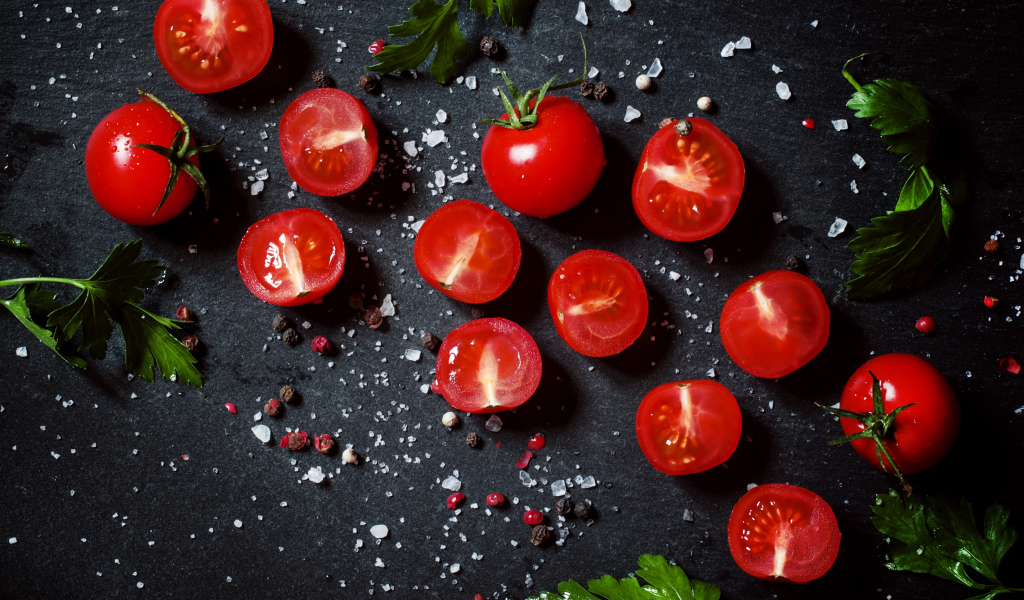 Помидоры на столе с зеленью петрушки и специями