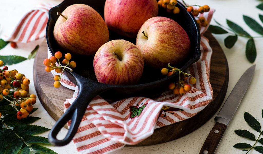 Красивые красные яблоки на сковороде с ягодами рябины