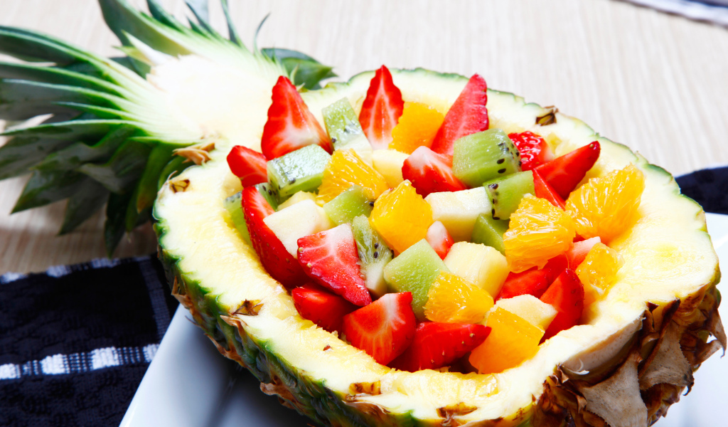 Фруктовый салат из цитрусовых  в тарелке из свежего ананаса 