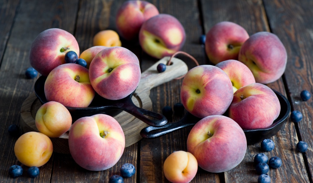 Сочные свежие персики, абрикосы и черника на столе