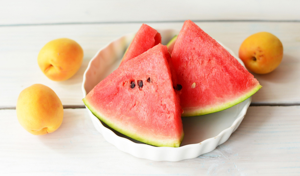 Кусочки сладкого арбуза с абрикосами на столе