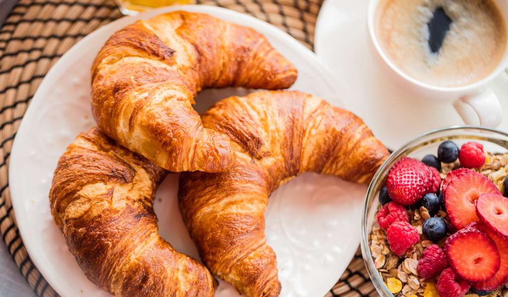 Три свежих круассана и мюсли с ягодами на завтрак