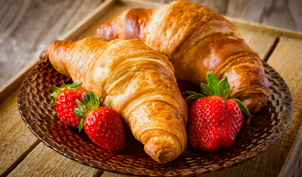 Два свежих круассана со свежей клубникой