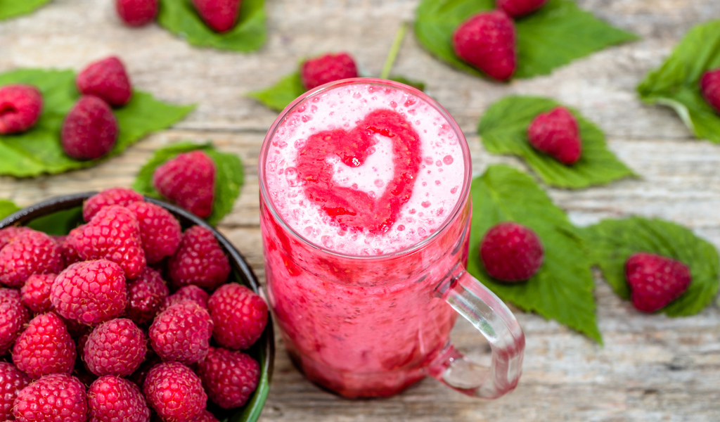 Бокал малинового коктейля со свежими ягодами малины