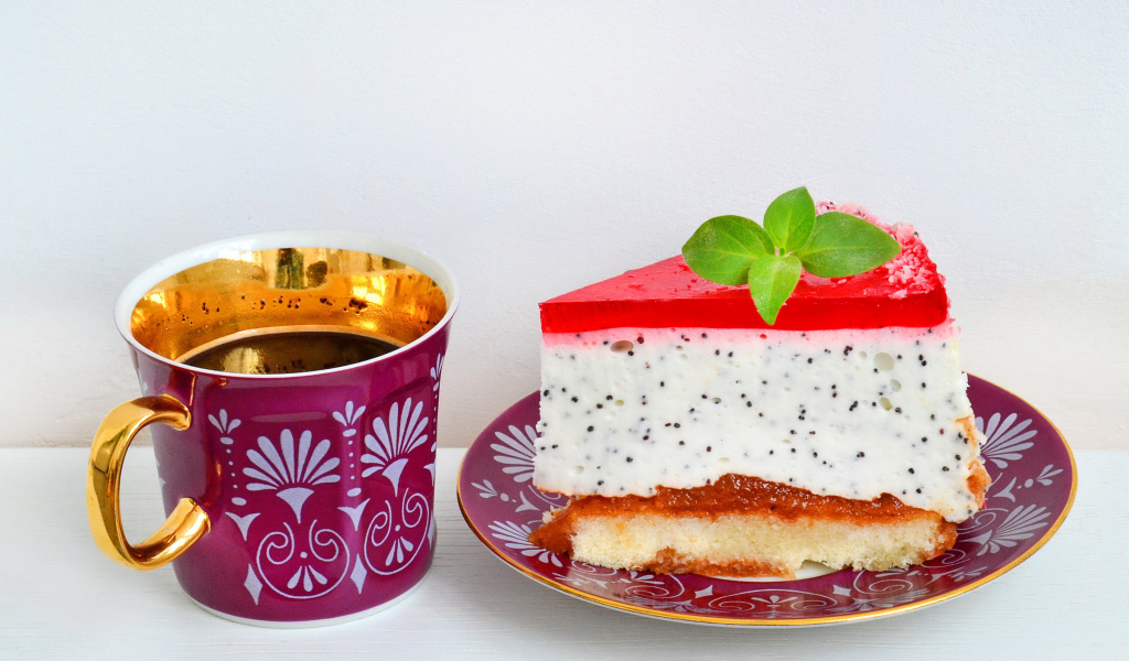 Кусок пирожного на тарелке с чашкой чая