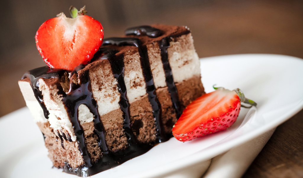 Кусок шоколадного пирожного со свежей клубникой