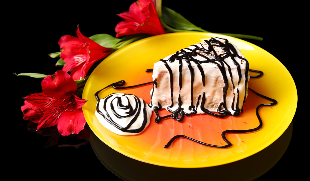 Аппетитное пирожное с шоколадом и цветком альстремерия на черном фоне