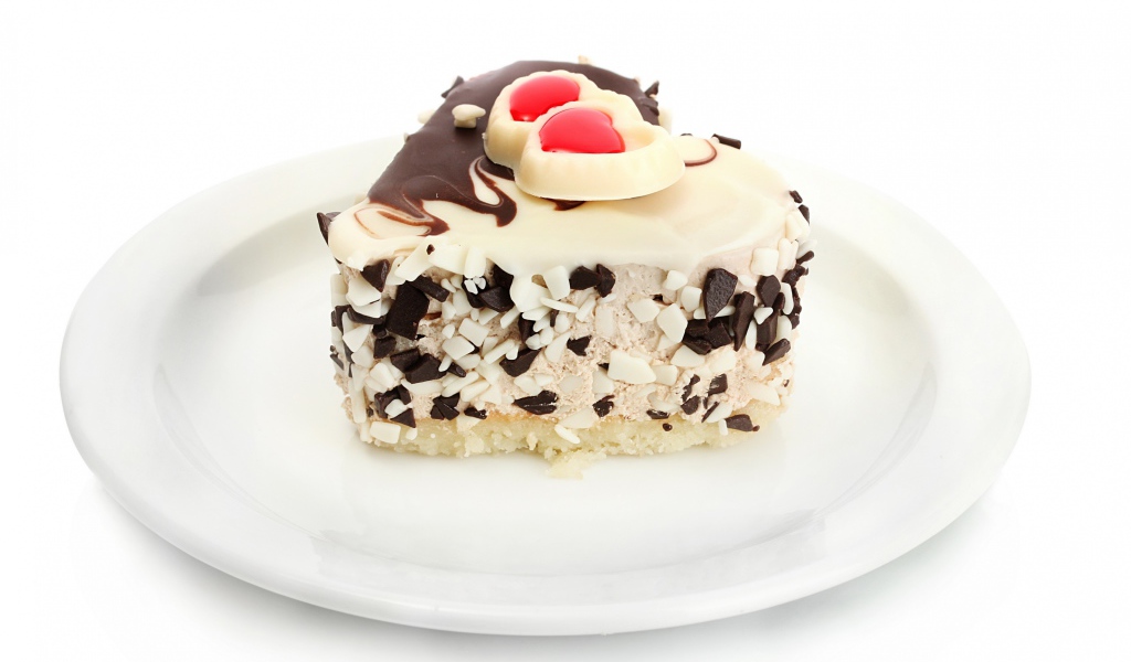 Аппетитное пирожное в форме сердца с шоколадом на белой тарелке