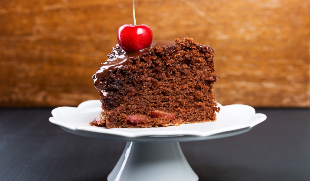 Аппетитный кусок пирога с шоколадом и ягодой черешни