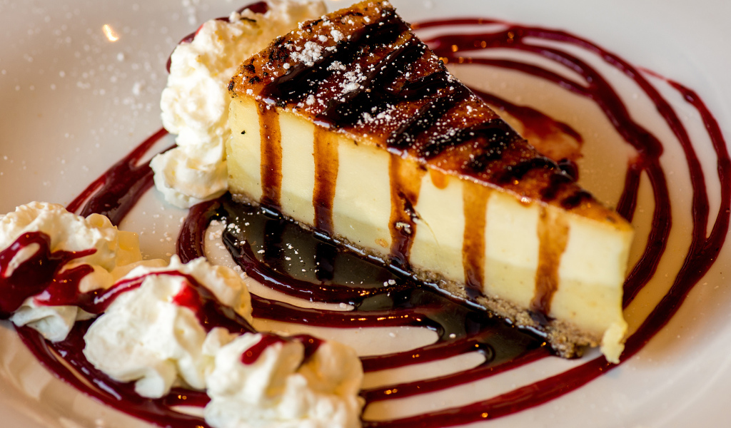 Аппетитный кусок чизкейка со сливками и клубничным джемом