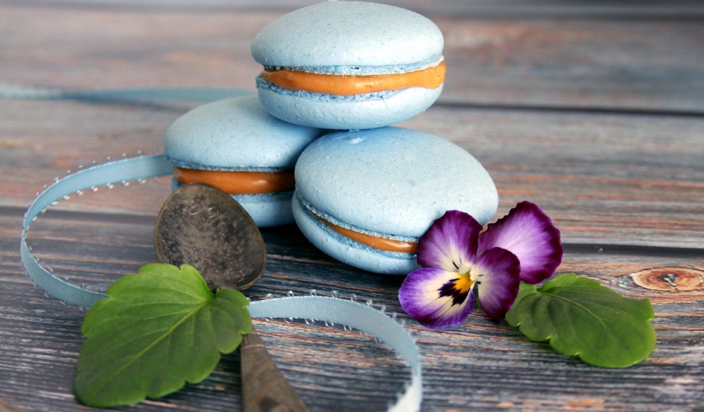 Голубые макаруны на столе с цветком 