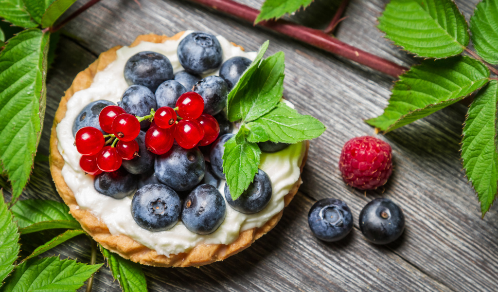 Пирожное со сливками и свежими ягодами смородины, черники и малины