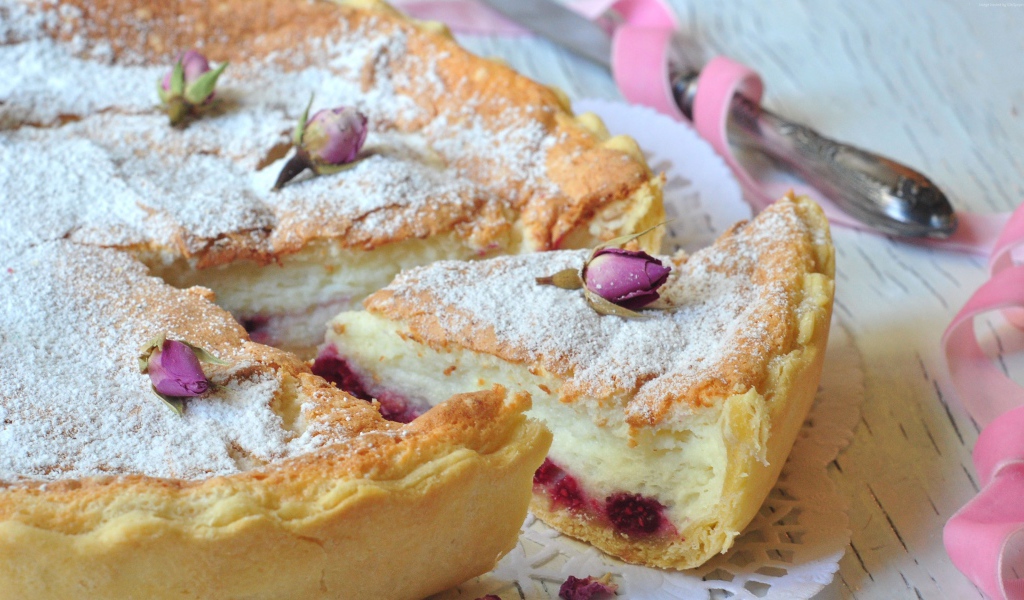 Пирог с суфле и малиной посыпанный сахарной пудрой и цветами