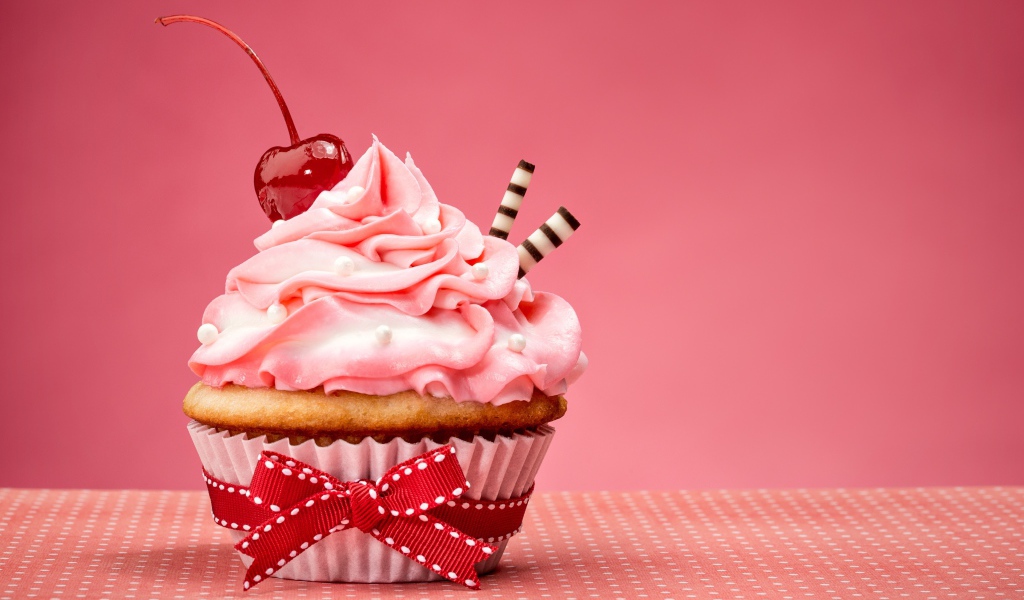 Капкейк с кремом и вишней красиво украшен лентой