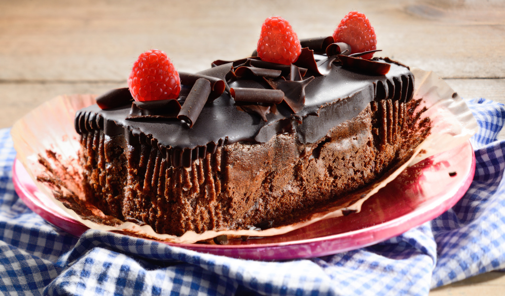 Шоколадное пирожное со свежей малиной на тарелке