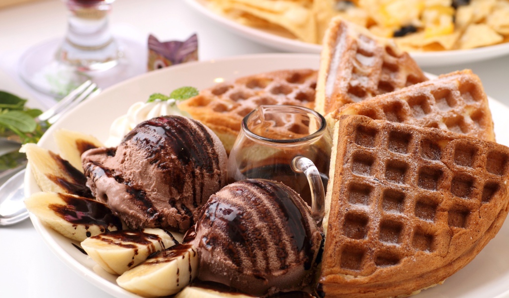 Кофейное мороженое с вафлями и бананами на тарелке