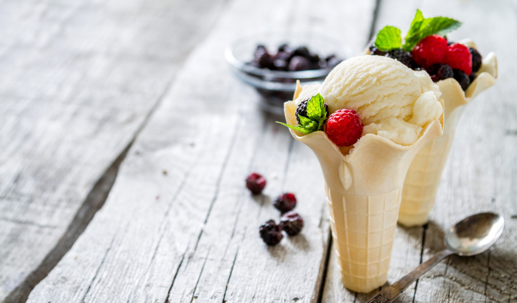 Сливочное мороженое в вафельном стаканчике с ягодами