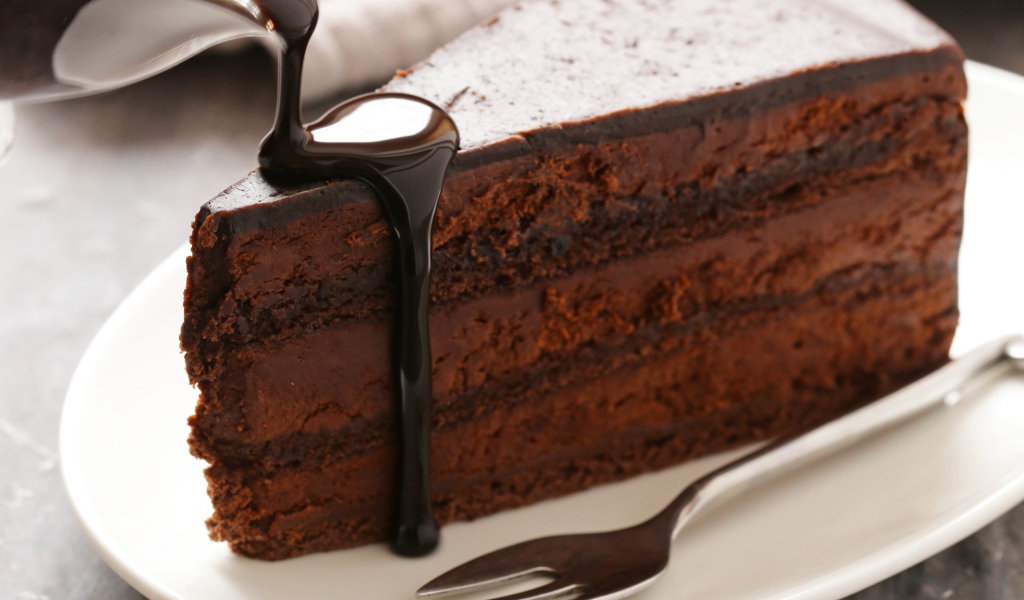 Вкусный торт на белой тарелке с шоколадом