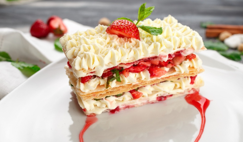 Вкусное сладкое пирожное с кремом и клубникой