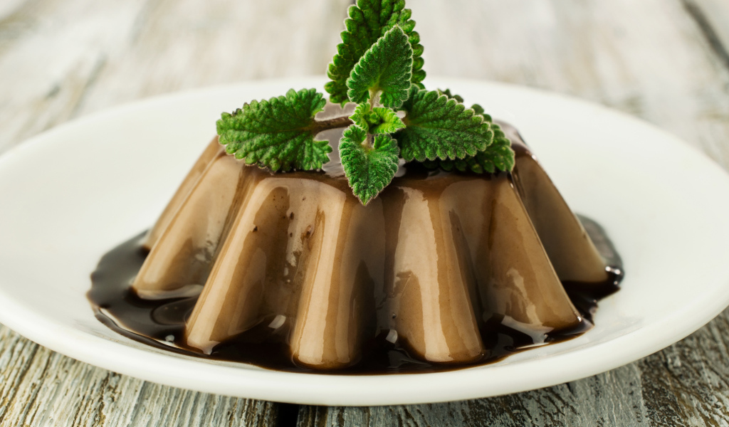 Десерт из желе на белой тарелке с шоколадом