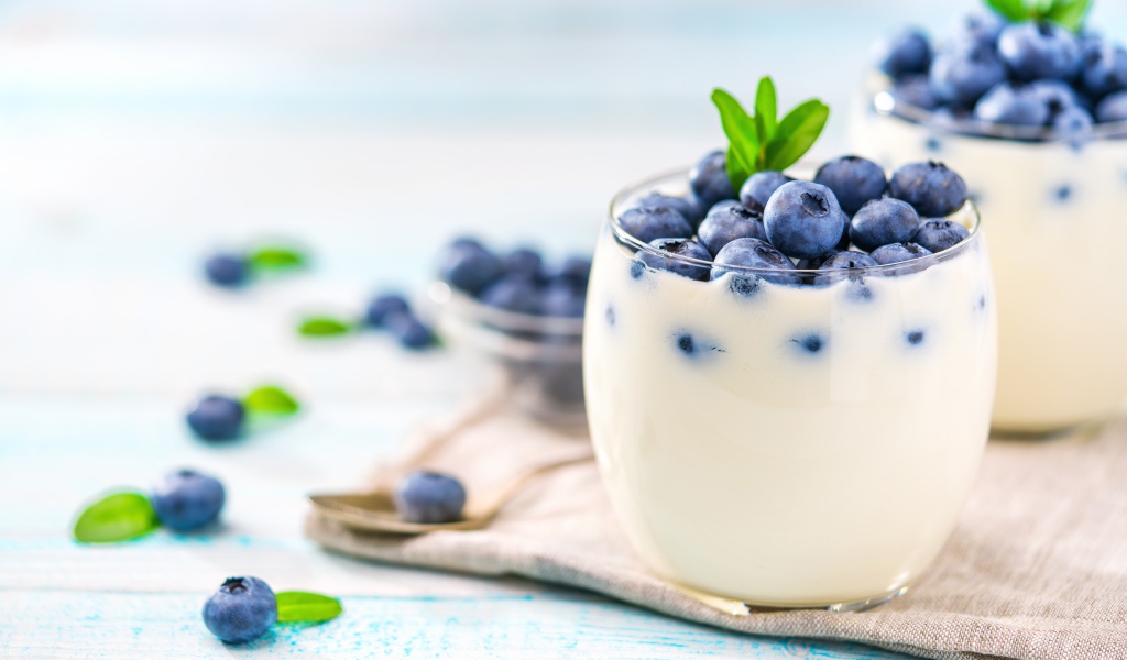 Десерт с йогуртом и ягодами черники с стеклянных стаканах