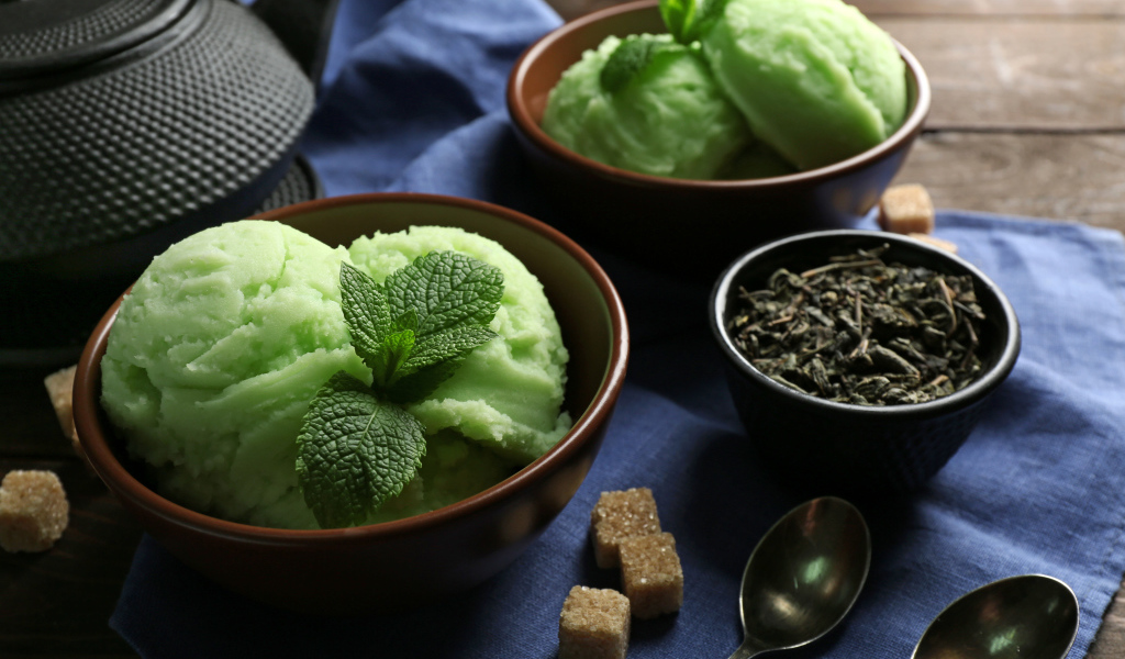 Зеленое мятное мороженое и кусочки сахара на столе 