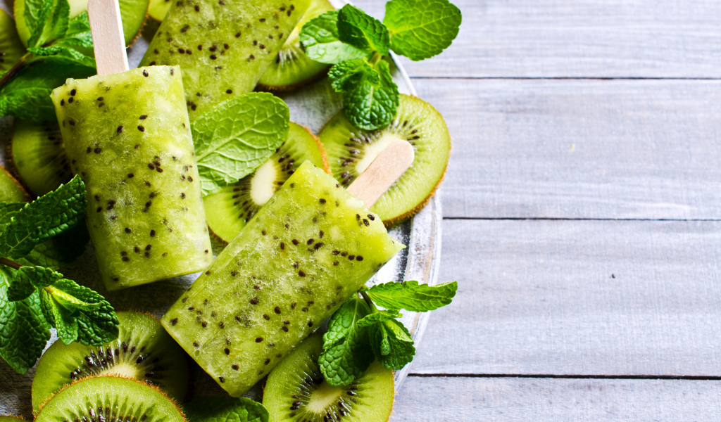 Мороженое с киви и листиками мяты на деревянном столе