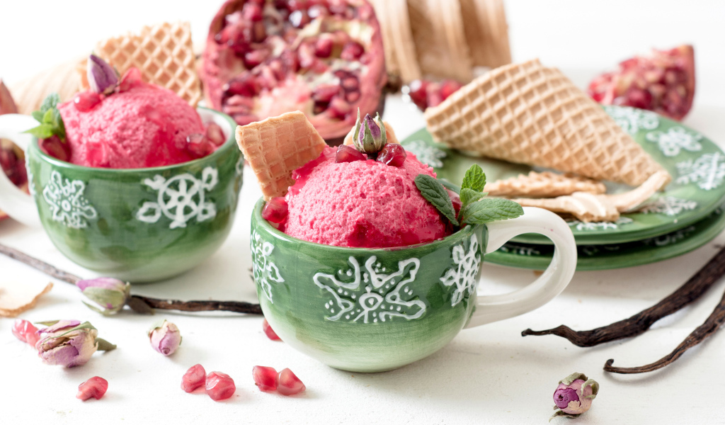 Мороженое с зернами граната в зеленых чашках на столе