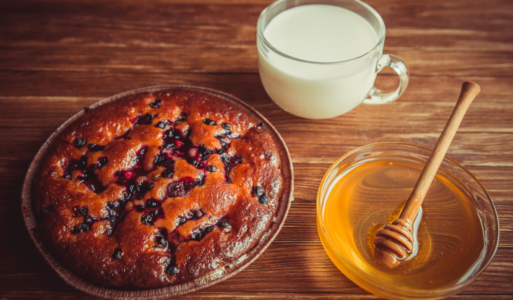 Пирог с ягодами, медом и молоком на столе