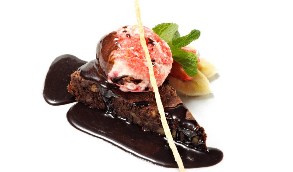 Кусок пирожного с шоколадом и шариком мороженого на белом фоне