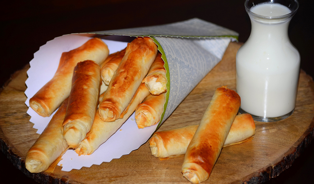 Сладкая выпечка с творогом на столе с кувшином молока