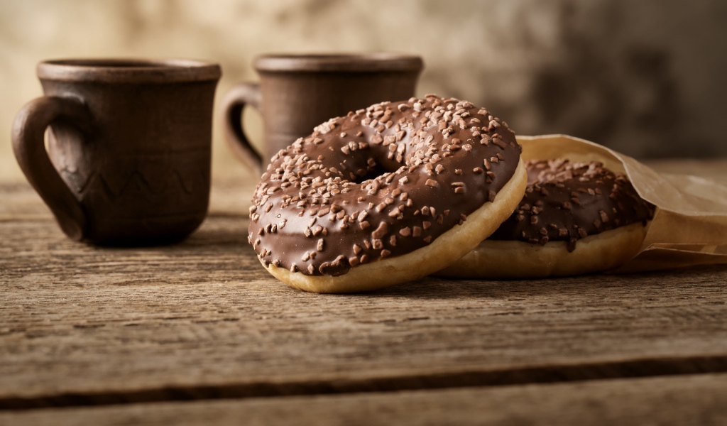 Сладкие круглые пончики с шоколадом на столе 